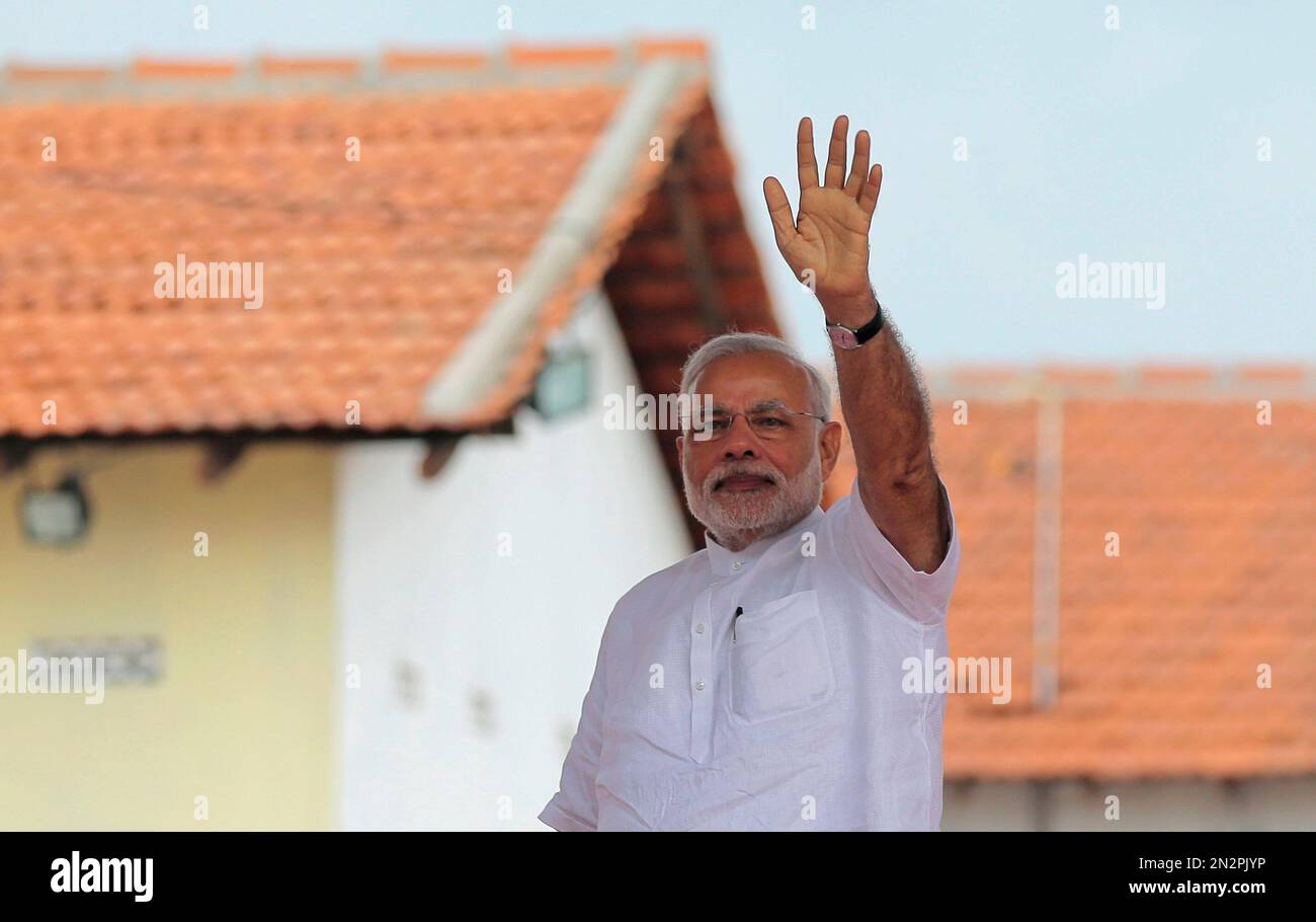 Indian Prime Minister Narendra Modi waves to the gathering during the handing over of homes under a housing scheme funded by the Indian government for war victims in Llavalai, northwest of Jaffna, Sri Lanka, Saturday, March 14, 2015. During his visit to north, Modi commissioned a section of railway track built with Indian aid in Talaimannar and ceremonially began the construction work of a cultural center to be built in the town of Jaffna with Indian assistance. Jaffna is the cultural heartland of the Tamils and was the stage of many battles during Sri Lanka's quarter century civil war. (AP Ph Banque D'Images