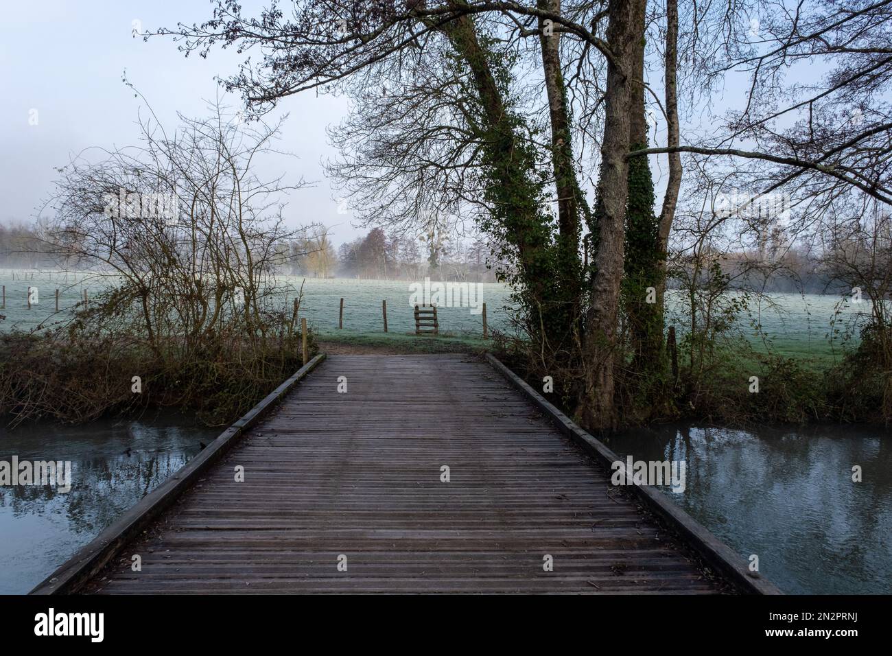 Passerelle en bois sur une rivière en hiver, France Banque D'Images