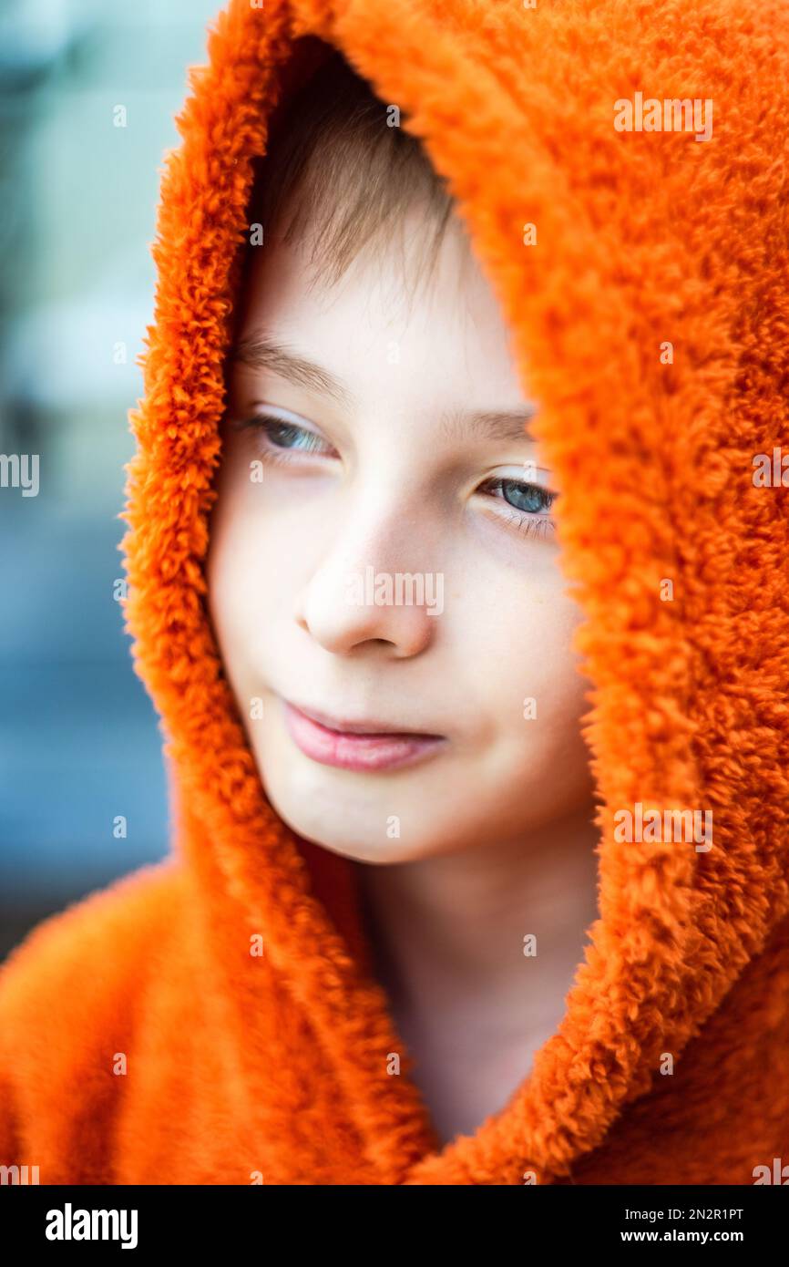 Portrait en gros plan d'un garçon portant un sweat à capuche orange Banque D'Images