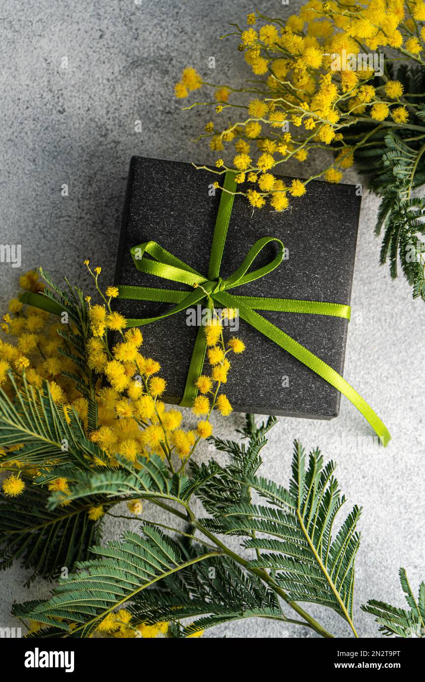 Vue en hauteur d'une boîte cadeau et de fleurs mimosa jaunes sur une table  Photo Stock - Alamy