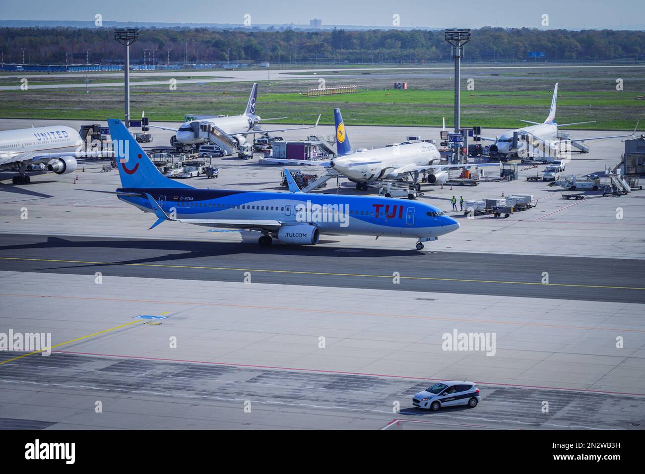 Un avion Blue Tui sur la piste de l'aéroport de Francfort avec d'autres avions en arrière-plan Banque D'Images