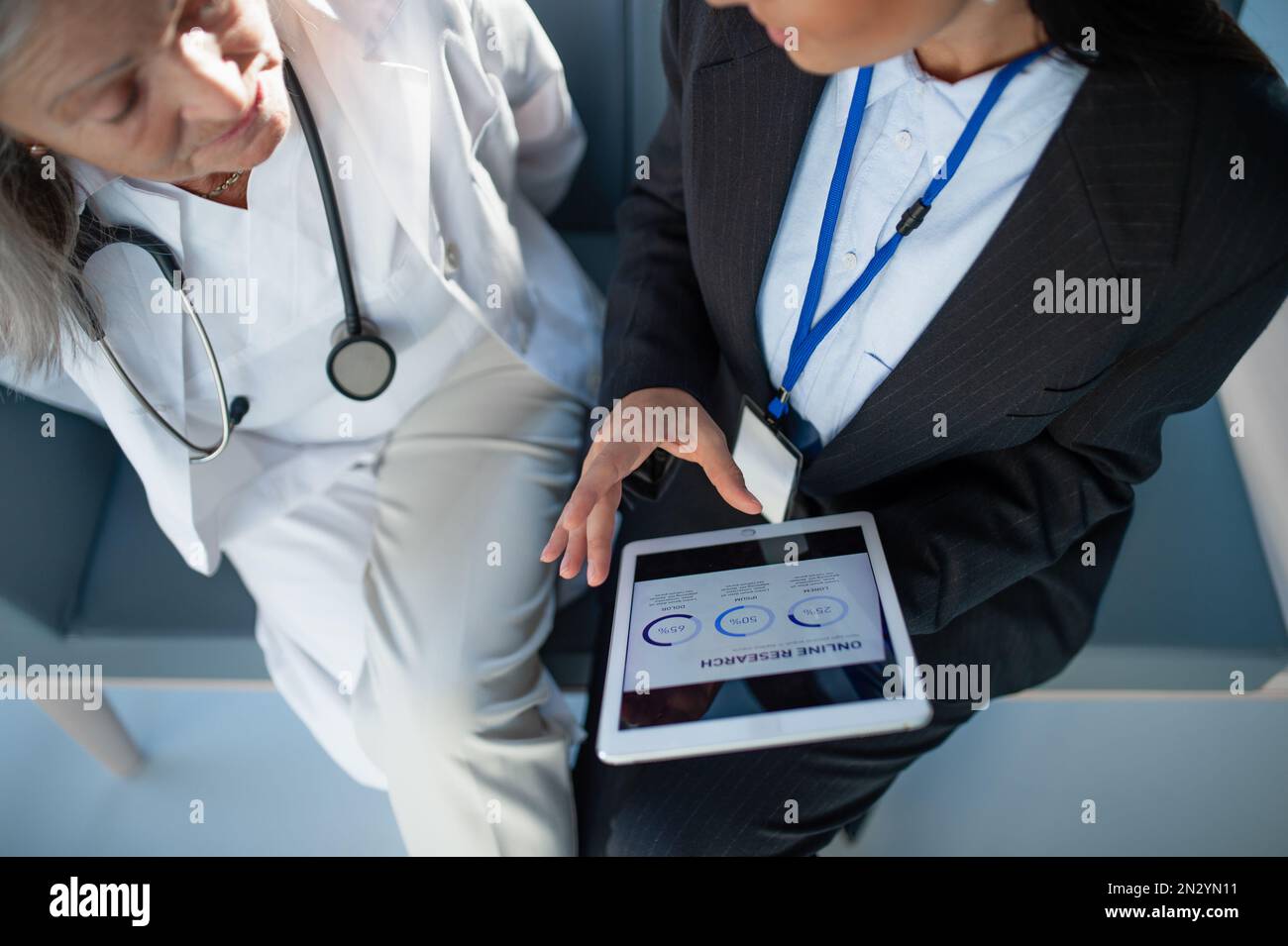 Vue en grand angle de la femme d'affaires montrant le tableau sur la tablette numérique au médecin. Banque D'Images