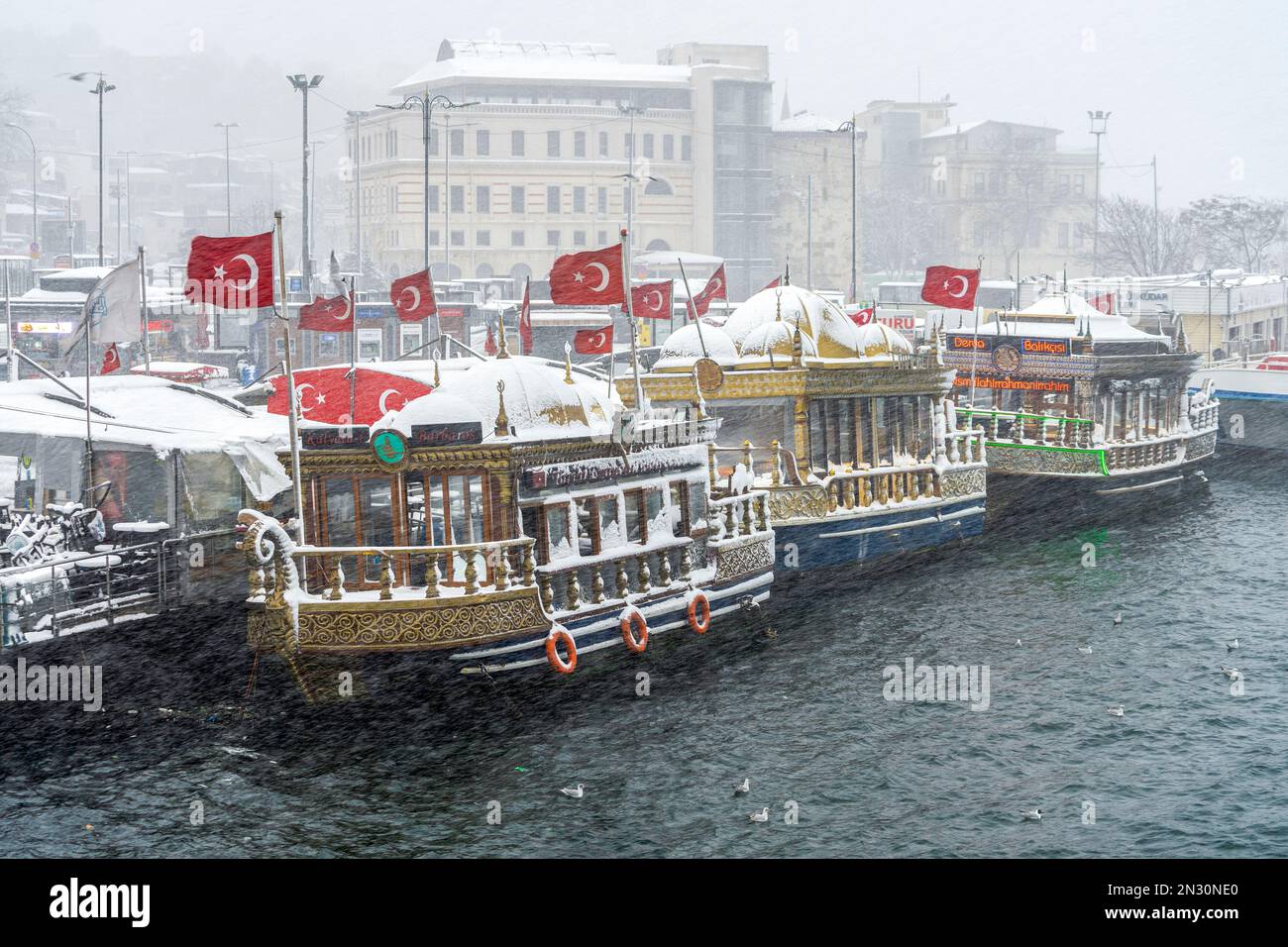 Restaurants de poissons enneigés sur des bateaux lors d'une journée d'hiver à Istanbul, Turquie. Banque D'Images