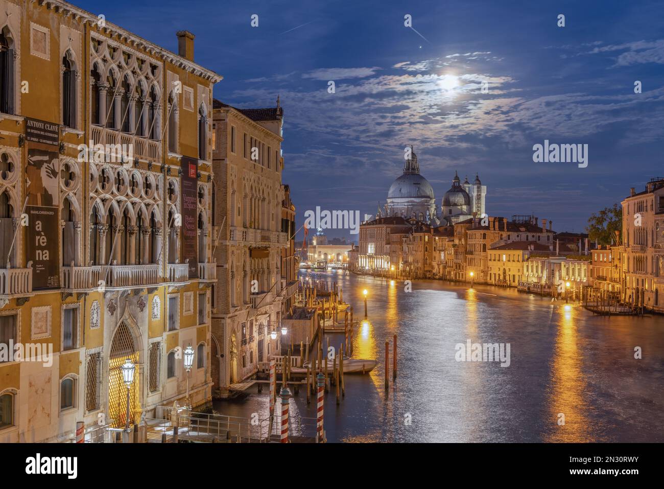 Venise, Italie, illuminée la nuit avec des canaux lumineux, une architecture historique, des ponts et des reflets sur l'eau. Banque D'Images