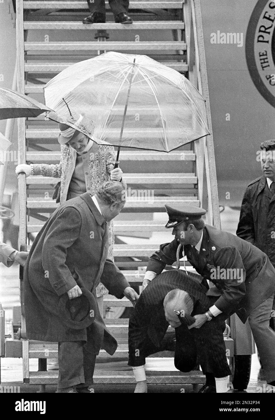 President Gerald Ford lands on his hands after slipping and falling on a wet ramp while deplaning Air Force One in Salzburg, Austria, June 1, 1975. A military aide, with an umbrella in hand, reaches to help break the president's fall. (AP Photo/Peter Bregg) Banque D'Images