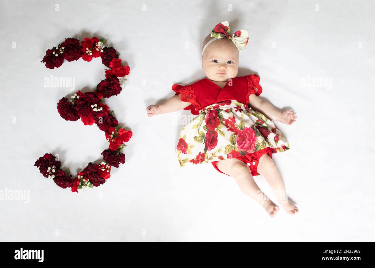 Petite fille de bébé nouveau-né en robe rouge. bébé de 3 mois Banque D'Images