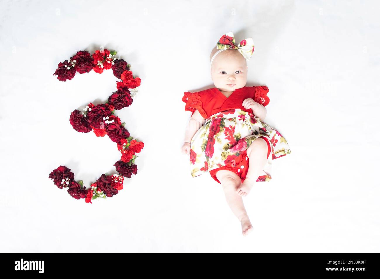 Petite fille de bébé nouveau-né en robe rouge. bébé de 3 mois Banque D'Images