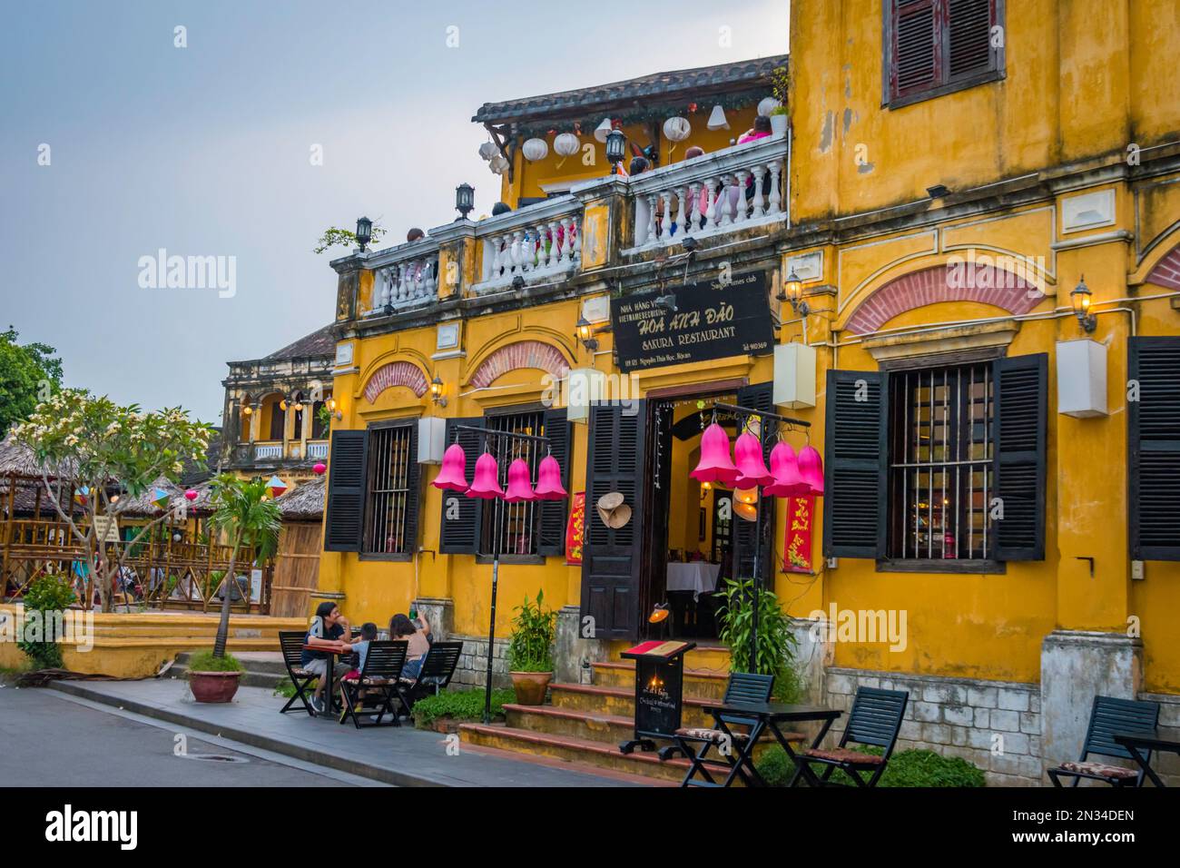 Lanternes violettes suspendues à l'entrée d'un restaurant jaune à Hoi an, Vietnam. Banque D'Images