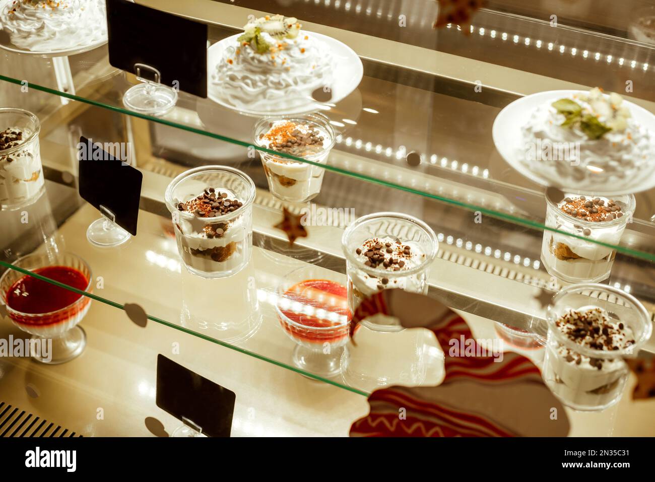Présentoir en verre avec dessert. Vitrine avec rétroéclairage dans le restaurant. Vente de dessert dans des tasses en verre Banque D'Images