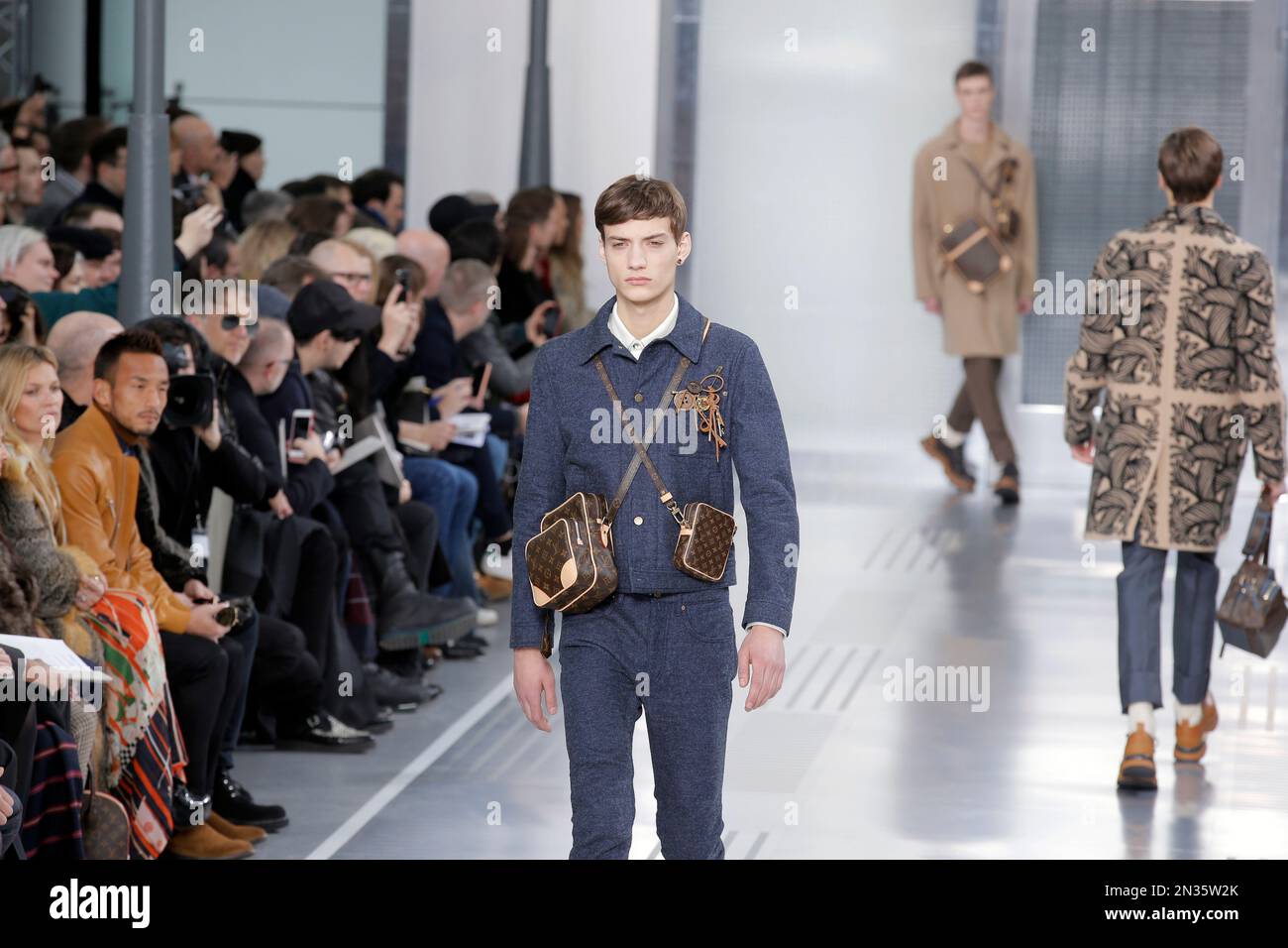 Models wear Louis Vuitton creations by fashion designer Kim Jones, as Kate Moss at left, looks on, during men's fall-winter 2015/2016 fashion collection presented in Paris, France, Thursday, Jan. 22, 2015. (AP Photo/Francois Mori) Banque D'Images