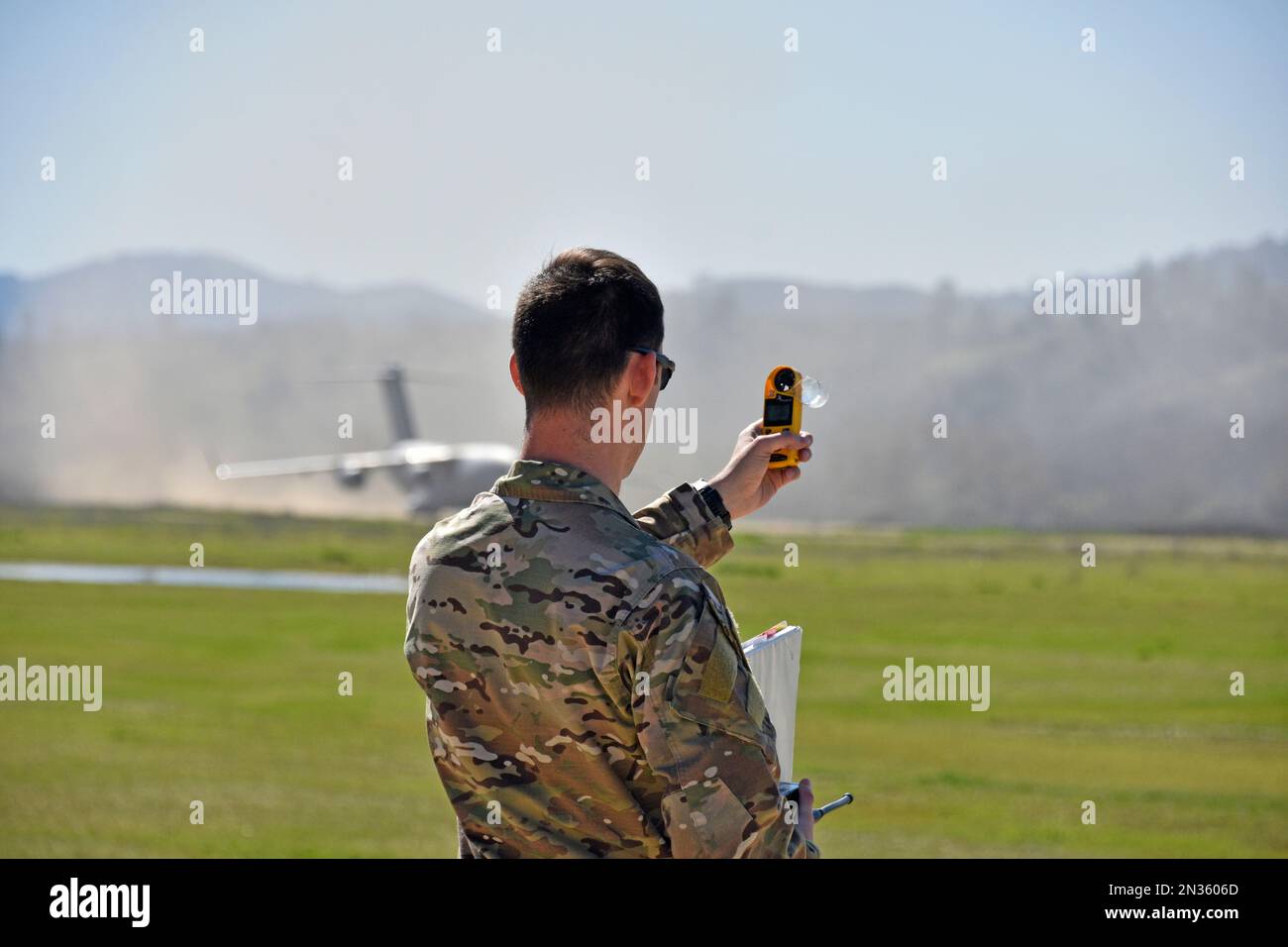 ÉTATS-UNIS Le capitaine de la Force aérienne vérifie la vitesse et la direction du vent en tant que C-17s de Travis AFB pratique l'atterrissage/les décollages sur la piste d'atterrissage en terre, fort Hunter Liggett, Calif Banque D'Images