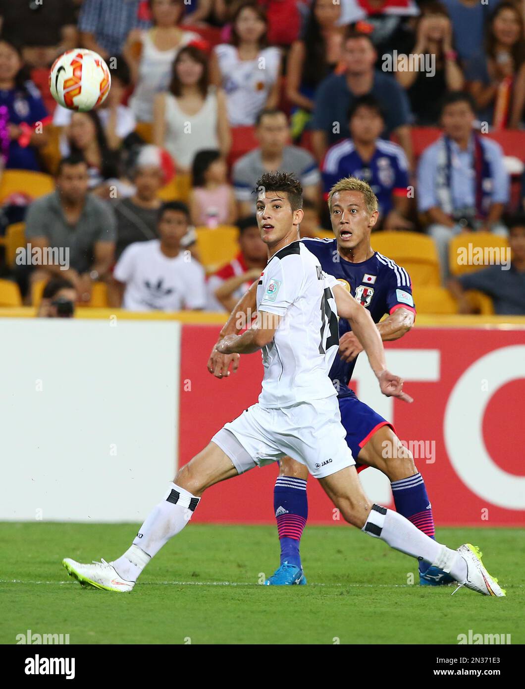 Japan’s Keisuke Honda kicks the ball past Iraq's Dhurgham Ismael Dawood during the AFC Asia Cup soccer match between Iraq and Japan in Brisbane, Australia, Friday, Jan. 16, 2015. (AP Photo/Tertius Pickard) Banque D'Images