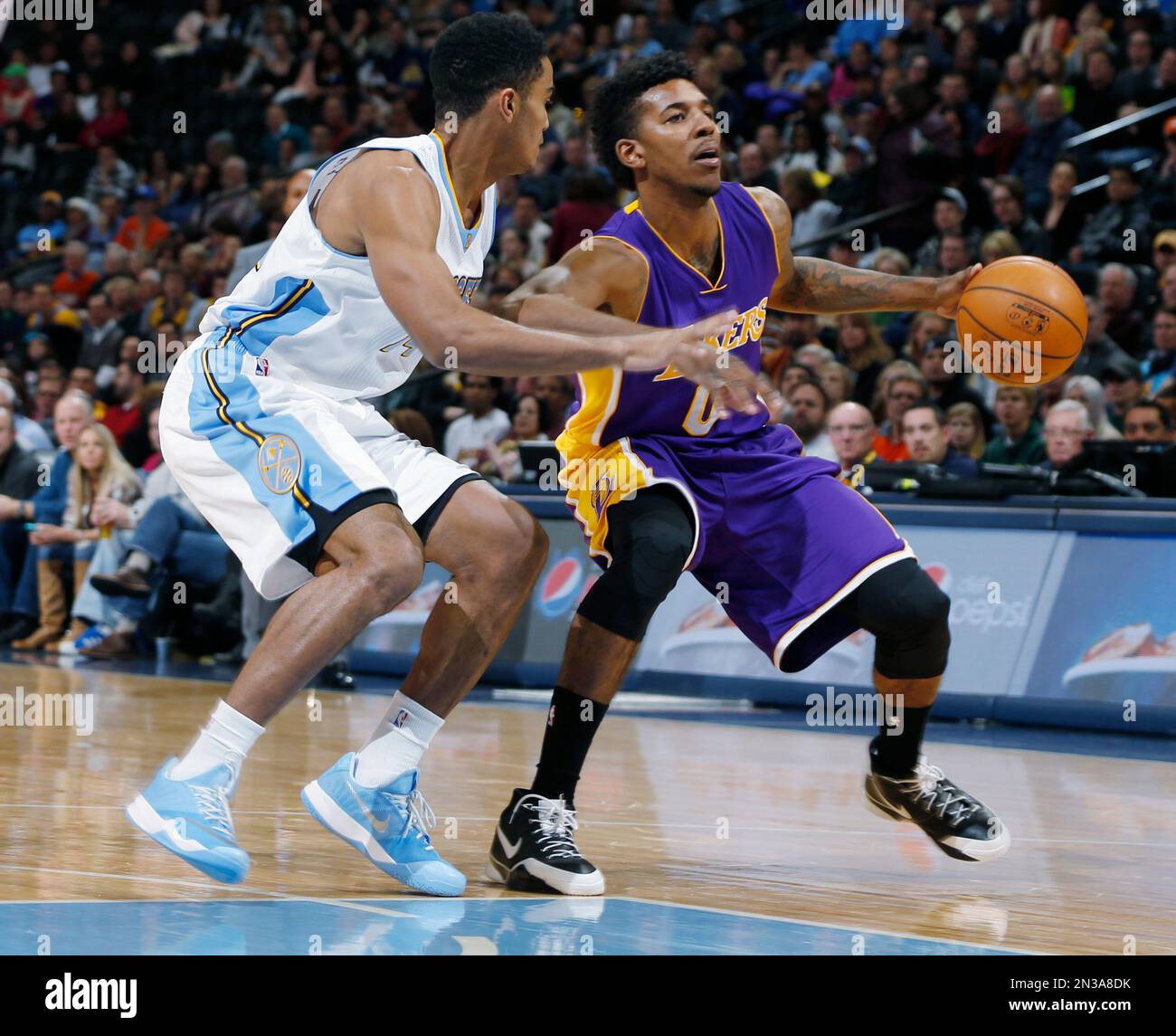 Los Angeles Lakers guard Nick Young, right, drives for a shot as Denver Nuggets guard Gary Harris defends during the first quarter of an NBA basketball game Tuesday, Dec. 30, 2014, in Denver. (AP Photo/David Zalubowski) Banque D'Images