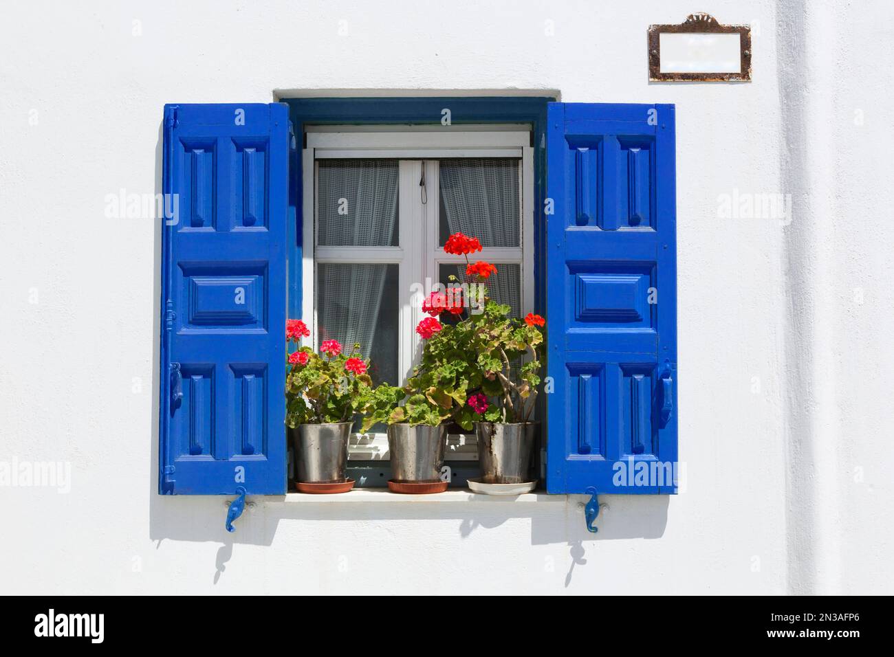 Fenêtre avec des volets bleus et des fleurs, Chora, la ville de Mykonos, Mykonos, Cyclades, îles grecques, Grèce Banque D'Images