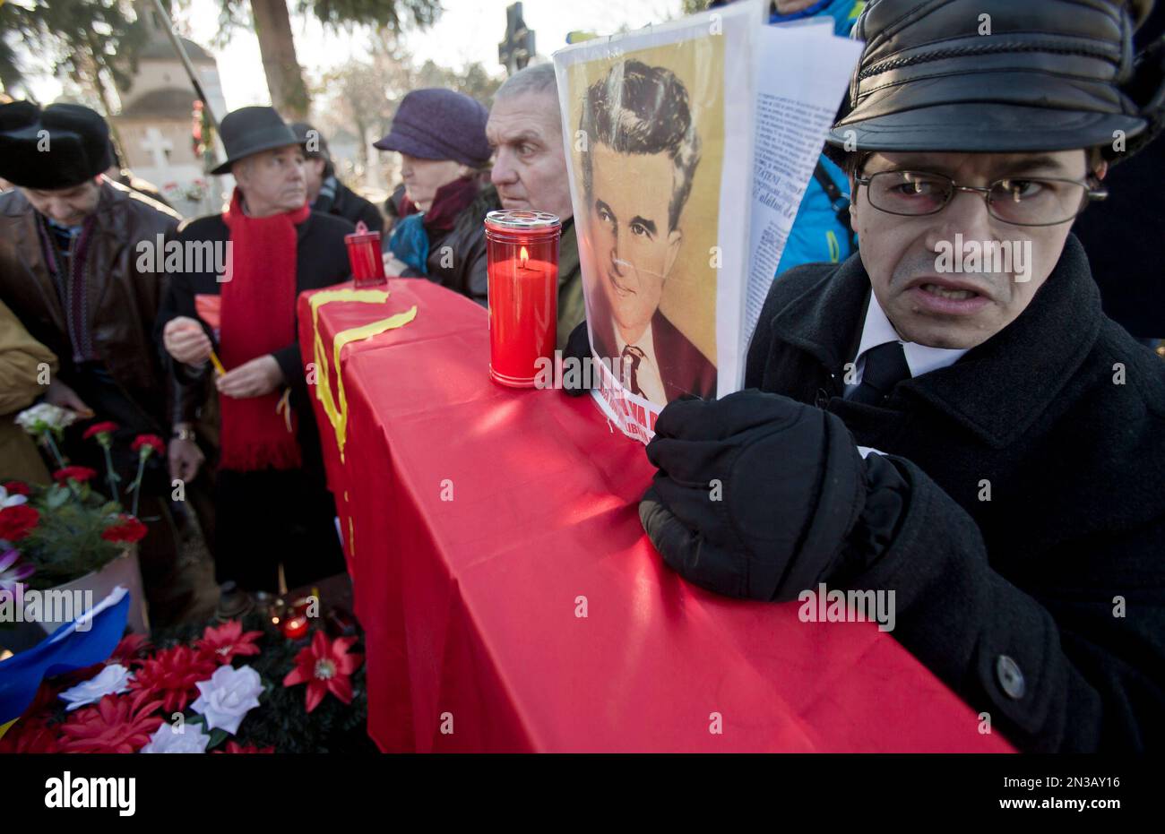 A man speaks holding a picture of Romanian communist dictator Nicolae ...