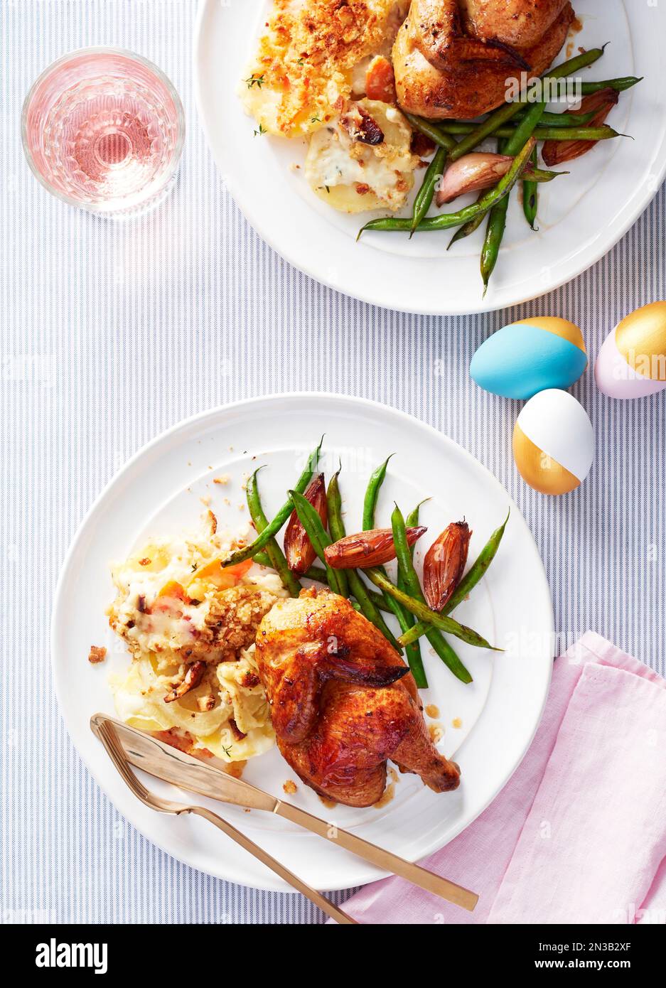 Deux assiettes avec des poules corniches, des pommes de terre aux noix de Saint-Jacques et des haricots verts pour le dîner de Pâques Banque D'Images