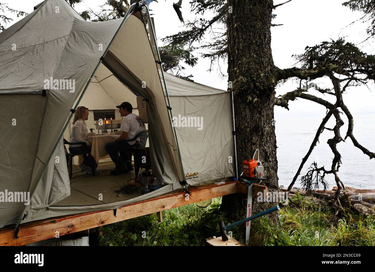 Pour une célébration d'anniversaire, un mari a surpris sa femme avec un dîner romantique aux chandelles dans une tente perchée au-dessus d'une plage isolée sur Prince o... Banque D'Images