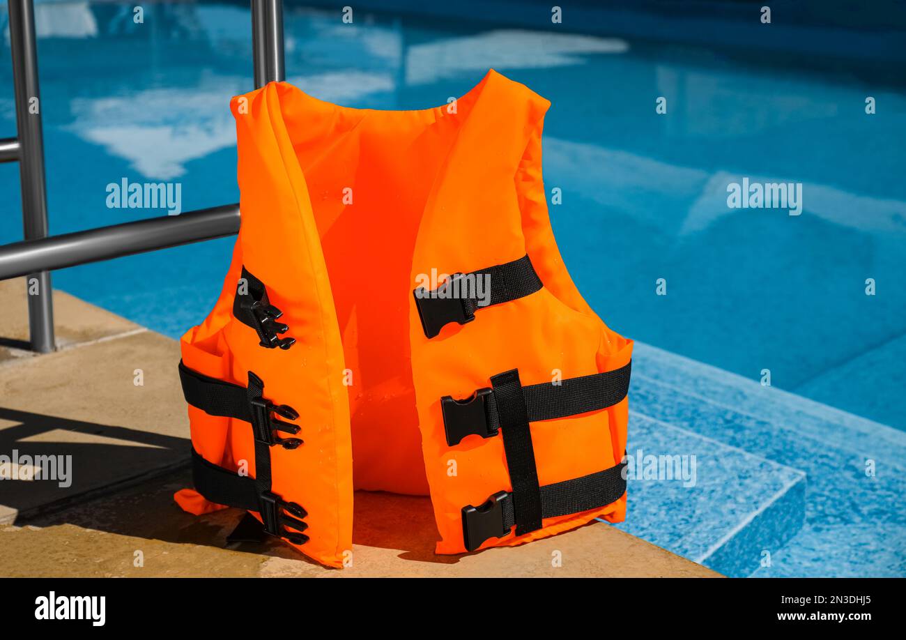 Gilet de sauvetage orange vif près de la piscine Photo Stock - Alamy