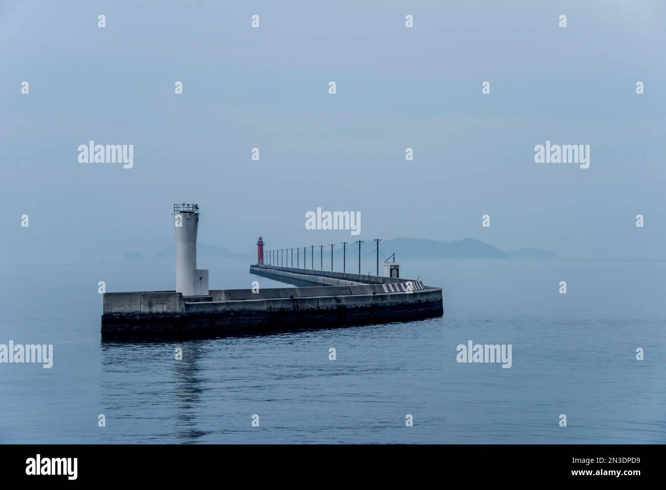 Structure de rupture d'eau et phare dans le port près de Naoshima, une ville insulaire dans la mer intérieure de Seto au Japon ; Shikoku, Japon Banque D'Images