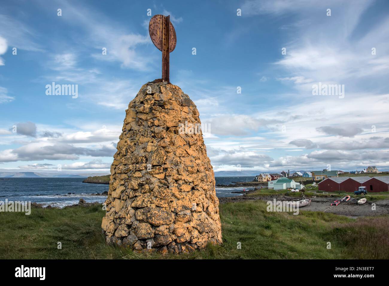 Formation de pierre avec réflecteur radar au sommet d'une colline surplombant le port de Flatey Island, faisant partie d'un amas d'une quarantaine de grandes et petites îles... Banque D'Images