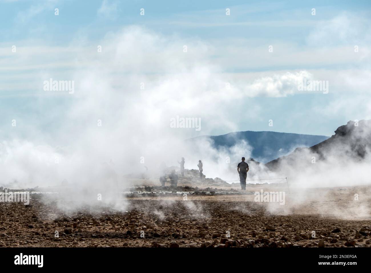 Les gens se tenant à la vue et prenant des photos du lac Myvatn, entouré par la vapeur qui s'élève des évents géothermiques. La région du lac Myvatn est... Banque D'Images