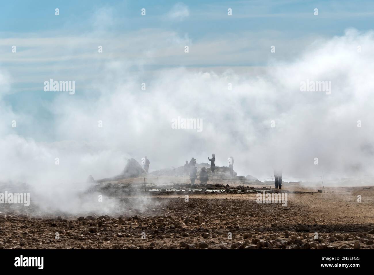 Les gens se tenant à la vue et prenant des photos du lac Myvatn, entouré par la vapeur qui s'élève des évents géothermiques. La région du lac Myvatn est... Banque D'Images
