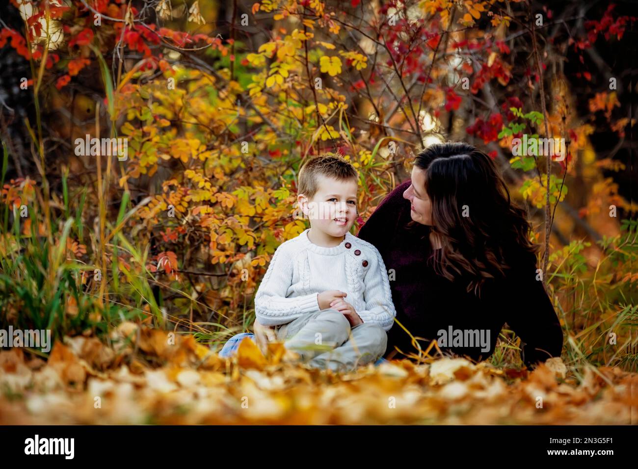 Une mère passe du temps de qualité et parle avec son jeune fils à l'extérieur dans un parc municipal pendant la saison d'automne; Edmonton, Alberta, Canada Banque D'Images