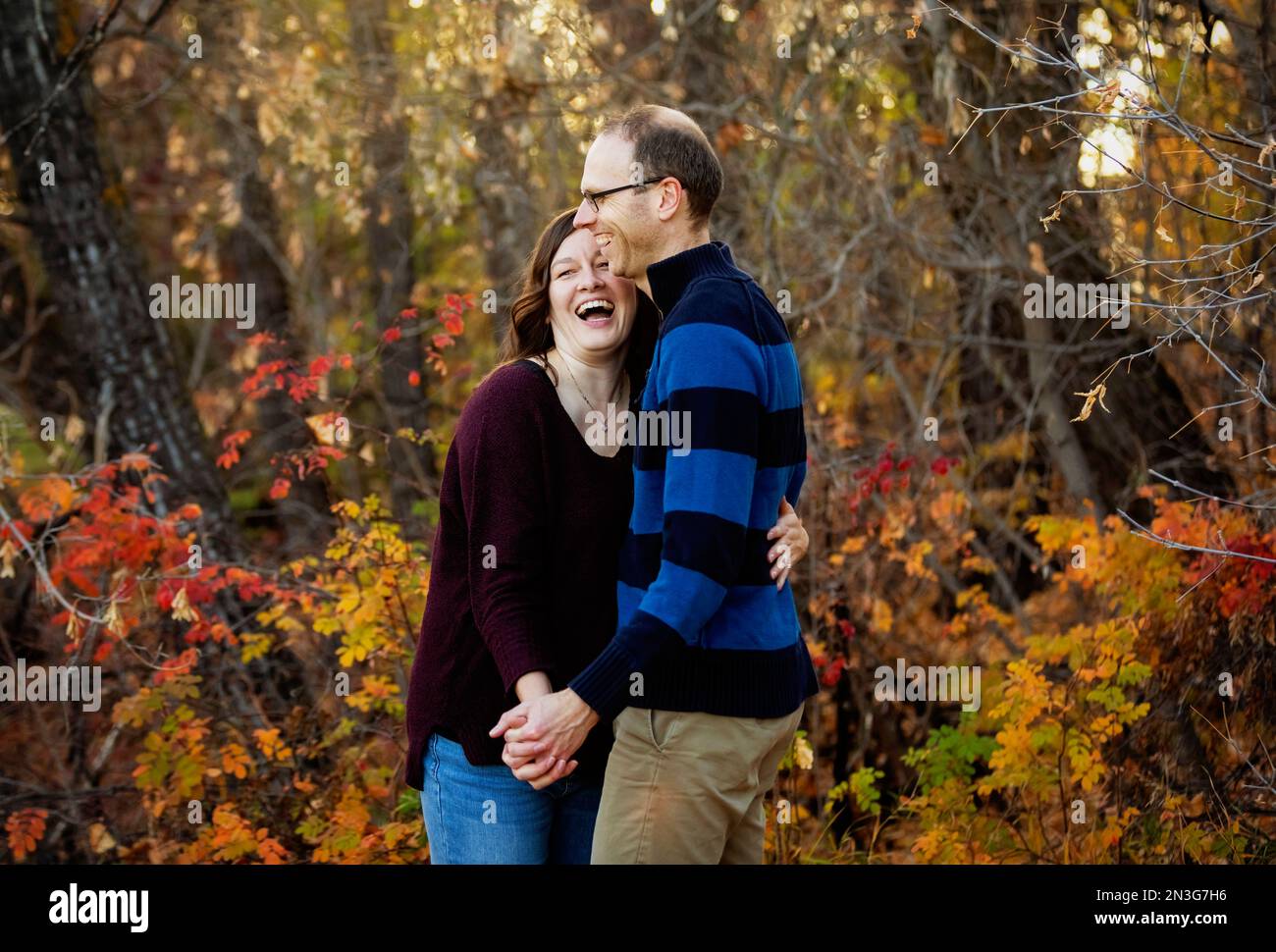 Couple marié mature passant du temps ensemble de qualité et dansant ensemble à l'extérieur dans un parc de la ville pendant la saison d'automne; St. Albert, Alberta, Canada Banque D'Images