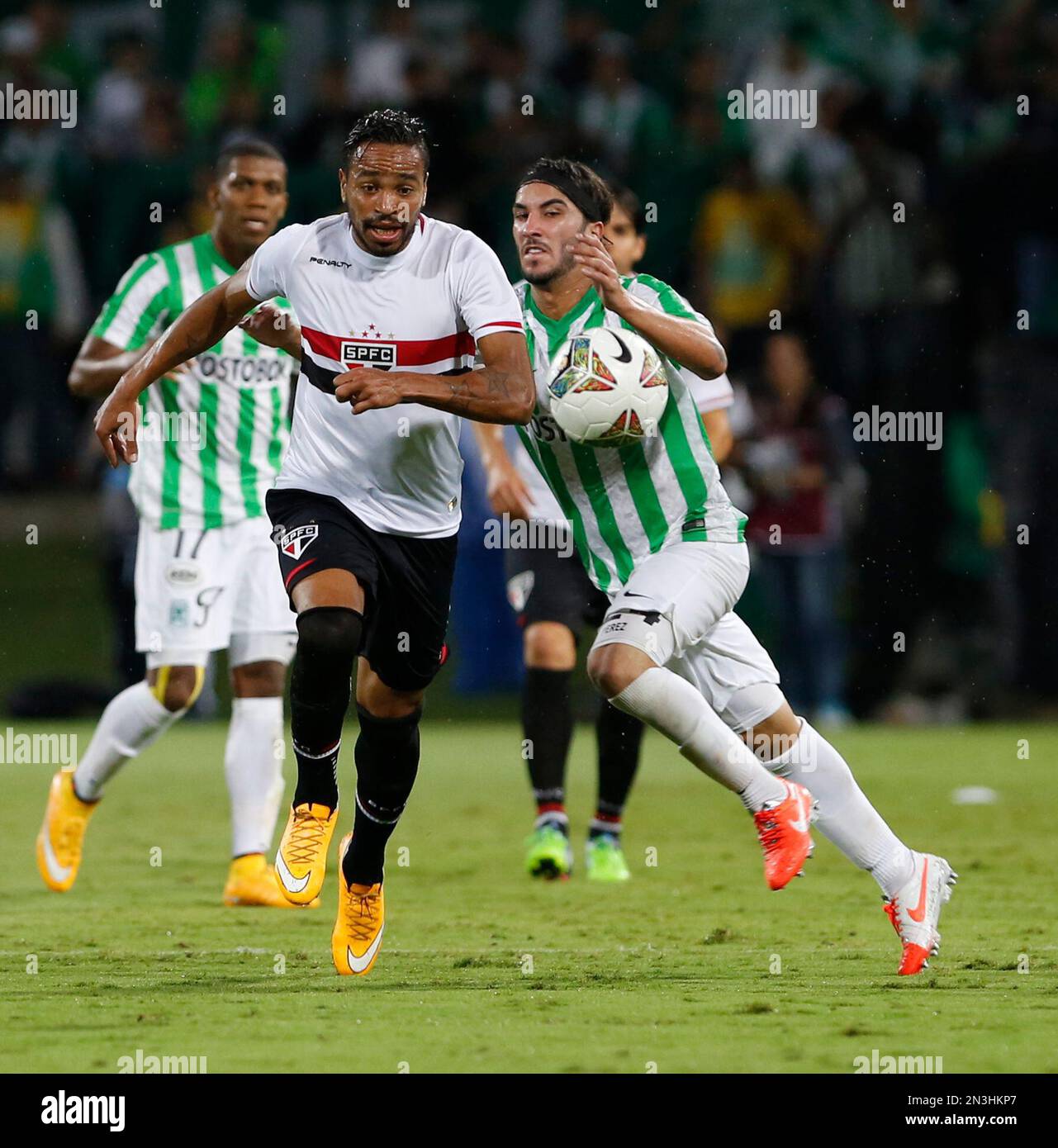 Alvaro Pereira of Brazil’s Sao Paulo, left, and Sebastian Perez of Colombia’s Atletico Nacional vie for the ball during a Copa Sudamericana semifinal soccer match in Medellin, Colombia, Wednesday, Nov. 19, 2014. (AP Photo/Fernando Vergara) Banque D'Images