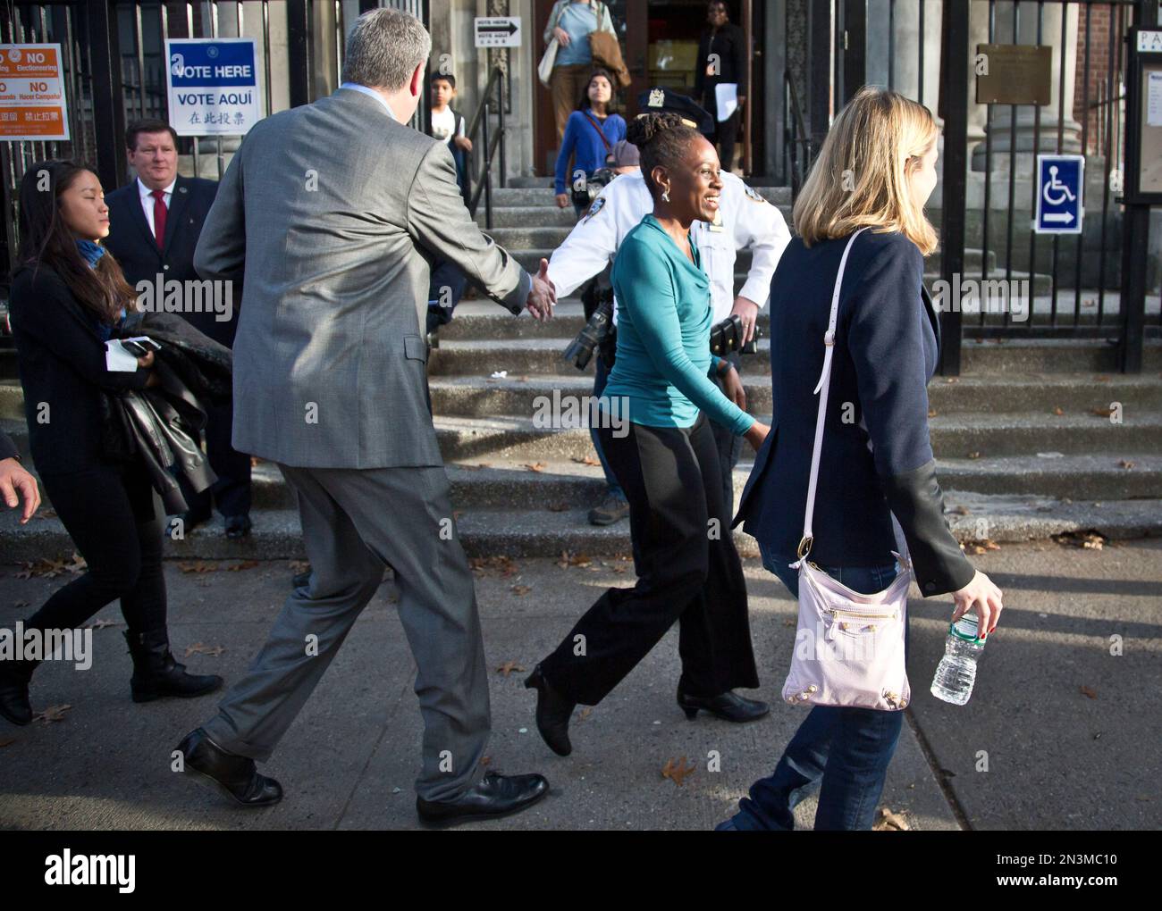 New York Mayor Bill de Blasio, left, shakes hands as he leaves a polling station with first lady Chirlane McCray, after they voted in the midterm elections, Tuesday Nov. 4, 2014 in New York. (AP Photo/Bebeto Matthews) Banque D'Images