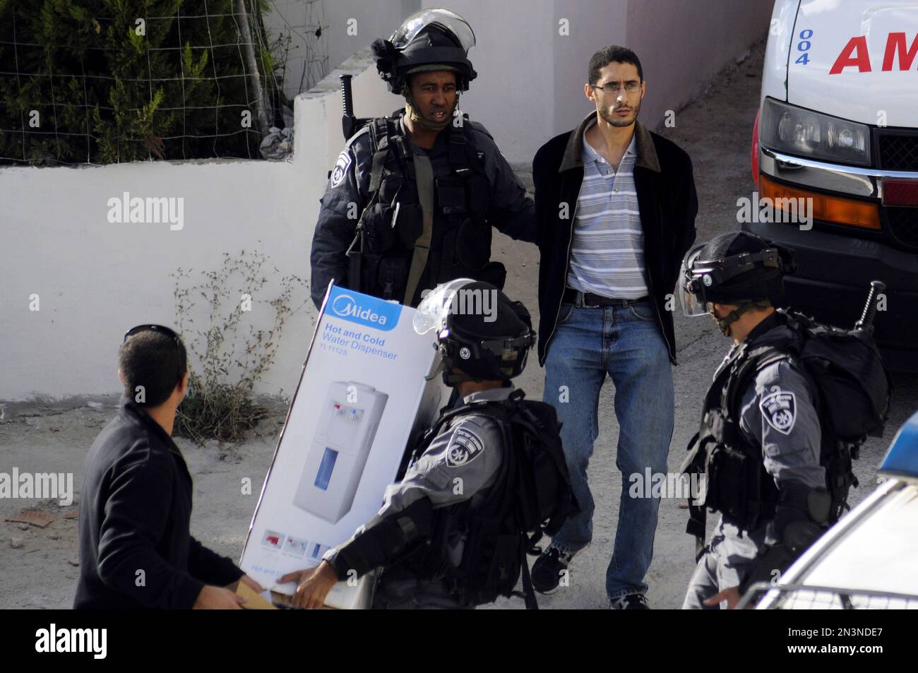 Israeli border policemen arrest the brother of Palestinian Moatez Higazi after he was shot in east Jerusalem, Thursday, Oct. 30, 2014. Israeli police shot and killed Higazi suspected of trying to kill a hard-line Jewish activist in Jerusalem, an incident that quickly sparked clashes between masked stone throwers and Israeli riot police, threatening to further enflame the already high tensions in the city. (AP Photo/Mahmoud Illean) Banque D'Images