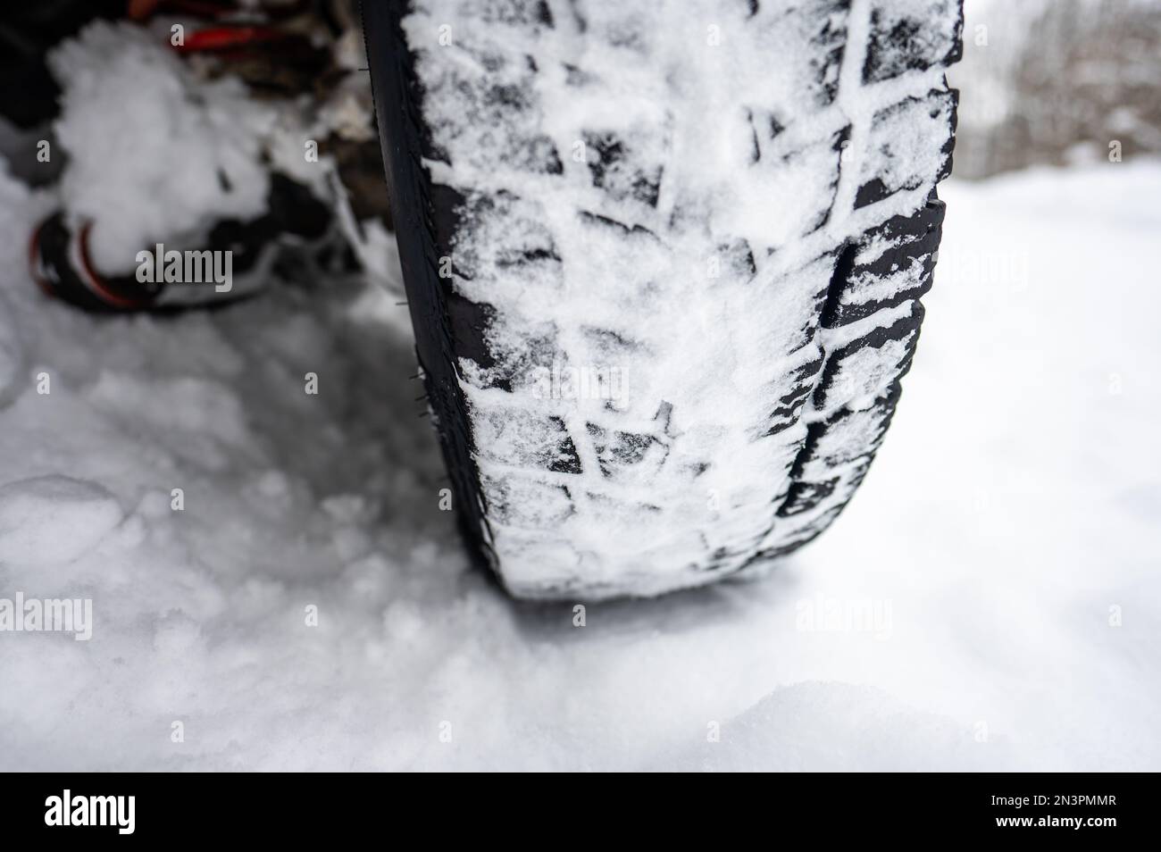 Gros plan de la bande de roulement d'un pneu 4x4 d'hiver sur une route enneigée. Banque D'Images