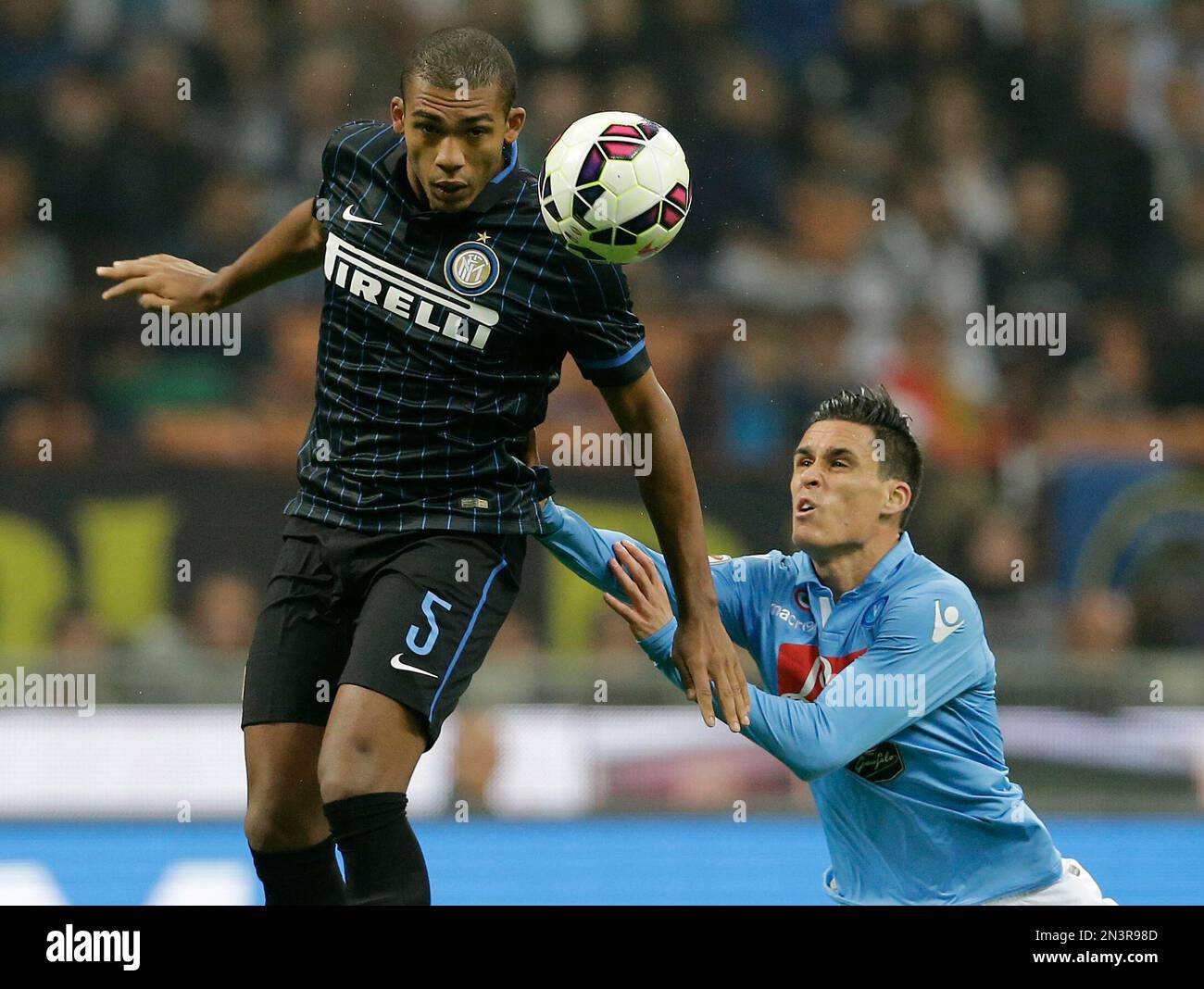 Inter Milan's Juan Jesus, left, challenges for the ball with Napoli’s Jose Callejon during the Serie A soccer match between Inter Milan and Napoli at the San Siro stadium in Milan, Italy, Sunday, Oct. 19, 2014. (AP Photo/Antonio Calanni) Banque D'Images