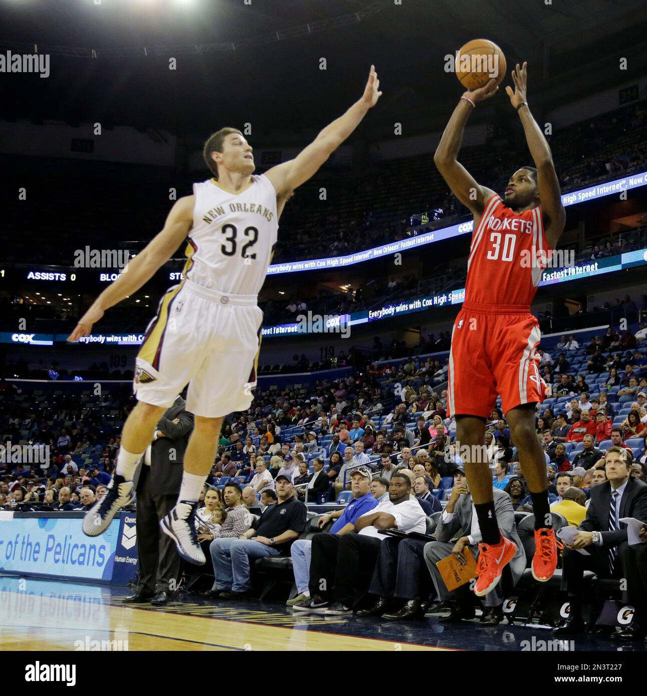 Houston Rockets guard Troy Daniels (30) shoots over New Orleans Pelicans guard Jimmer Fredette (32) during the first half of an NBA preseason basketball game in New Orleans, Tuesday, Oct. 14, 2014. (AP Photo/Bill Haber) Banque D'Images
