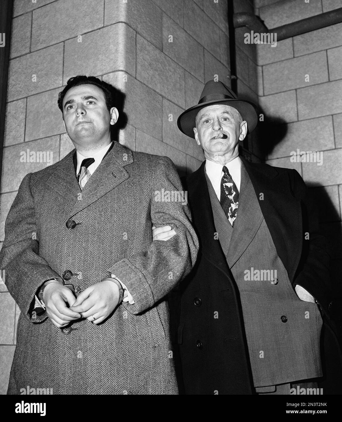 FILE - In this April 6, 1951, file photo, David Greenglass, left, arrives at Federal Court led by U.S. Deputy Marshal Eugene Fitzgerald in New York for sentencing as a member of an atomic spy ring which passed on secrets to Russia. Greenglass pleaded guilty. The former Army sergeant whose testimony led to the conviction and execution of his sister, Ethel Rosenberg and brother-in-law, Julius Rosenberg, died on July 1. He was 92. (AP Photo/File) Banque D'Images