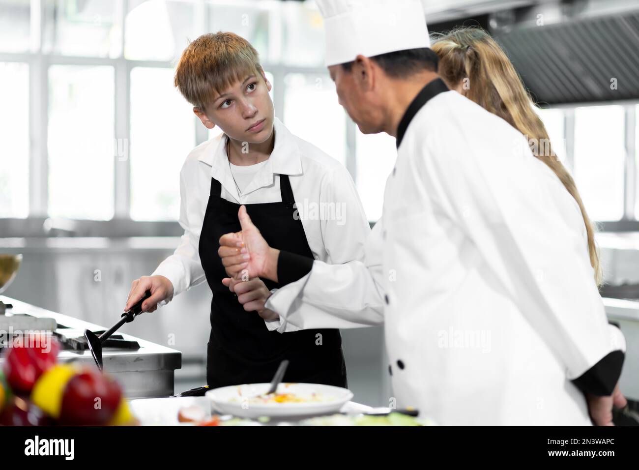 Les étudiants apprennent à cuisiner dans un institut culinaire doté d'une cuisine standard et d'un équipement complet. Et avoir un chef professionnel comme entraîneur. Banque D'Images
