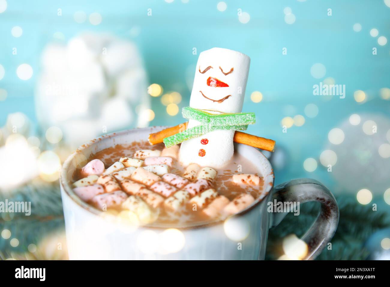 Bonhomme de neige en forme de guimauve amusant en tasse avec boisson chaude, en gros plan. Effet bokeh Banque D'Images