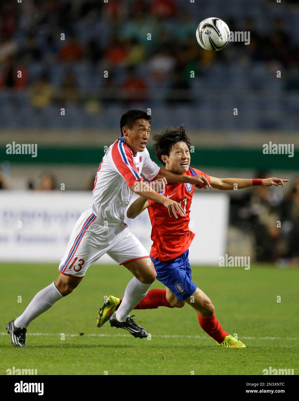 North Korea's Sim Hyon-jin, in white, and South Korea's Lee Jae-sung run to take control of the ball during their men's Soccer final match at the 17th Asian Games in Incheon, South Korea, Thursday, Oct. 2, 2014. (AP Photo/Dita Alangkara) Banque D'Images