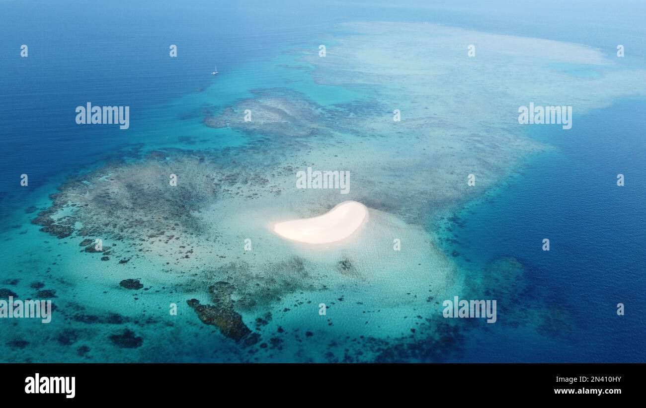 Photo aérienne d'une petite cay de sable entourée d'un récif de fringement dans la Grande barrière de corail Banque D'Images