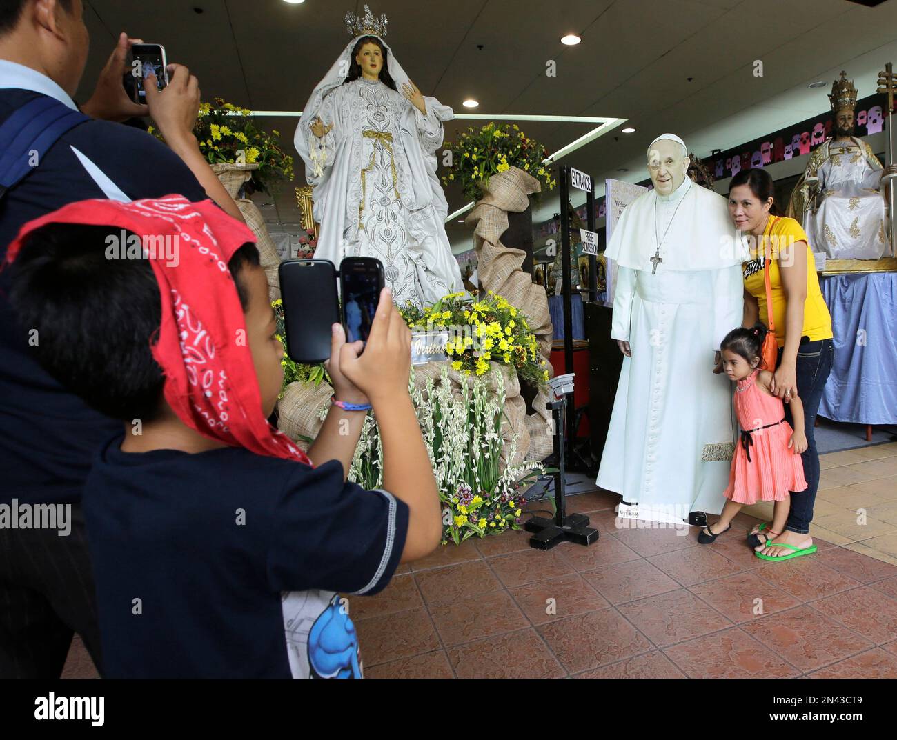 Filipinos have their photos taken with a cardboard cutout of Pope