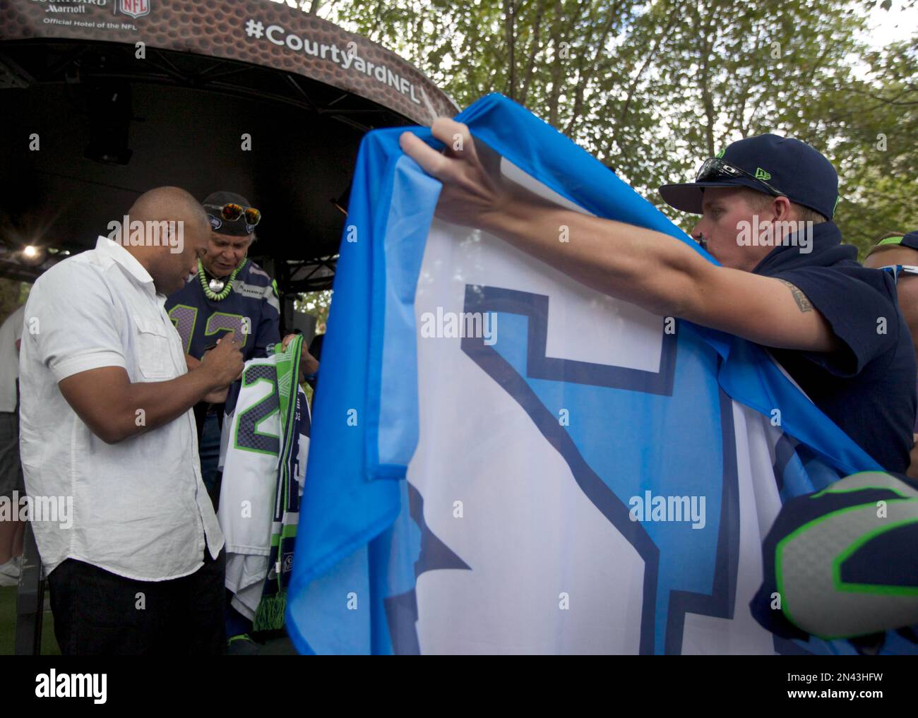 In this photo provided by Courtyard, former NFL MVP and Seattle Seahawks running back Shaun Alexander signs autographs for fans at the Courtyard NFL Kickoff Experience Wednesday Sept. 3, 2014, in Seattle. (Photo by Stephen Brashear/Invision for Courtyard/AP Images) Banque D'Images