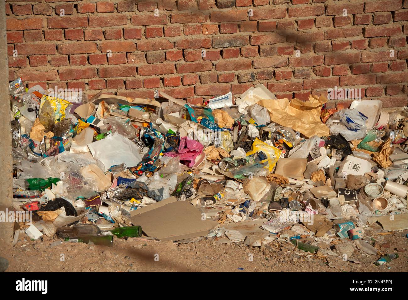 Tas de déchets et de déchets près du mur de briques à Hurghada, en Égypte Banque D'Images