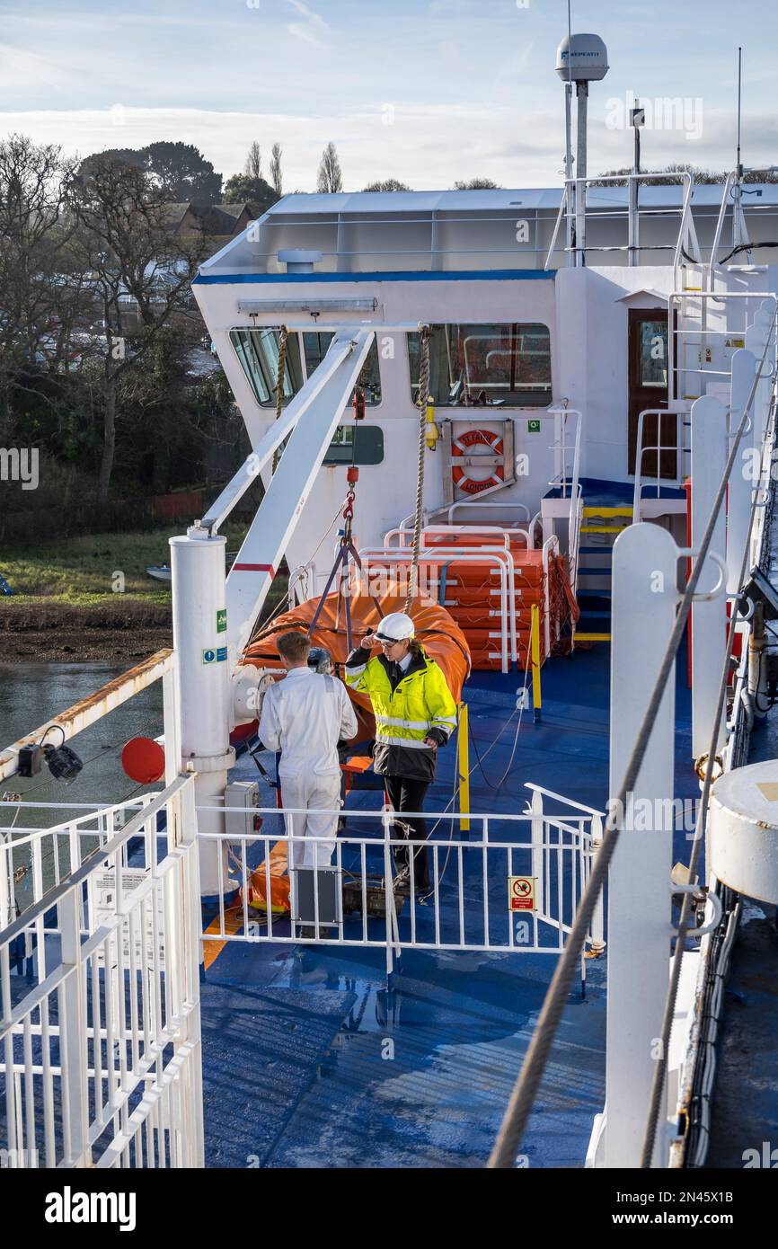 Deux membres de l'équipage de Wightlink discutant du problème avec la grue de lancement du bateau de sauvetage traversier de Saint Faith Fishbourne Isle of Wight 2023 Banque D'Images