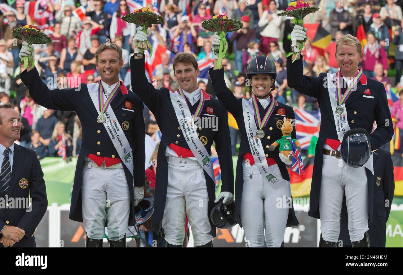 Britain's silver medalists from left, Carl Hester, Michael Eilberg, Charlotte Dujardin and Gareth Hughes, pose on the podium during the medal ceremony of the dressage team competition at the FEI World Equestrian Games, at Michel d'Ornano stadium in Caen, western France, Tuesday, Aug. 26, 2014. Germany won head of Great Britain finishing second and the Netherlands finishing third. (AP Photo/Michel Euler) Banque D'Images
