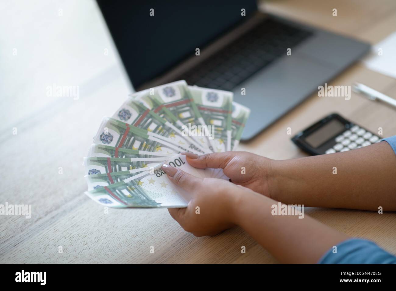 Femme négociant comptant l'argent comptant, détenant un groupe d'euros, bureau à domicile Banque D'Images