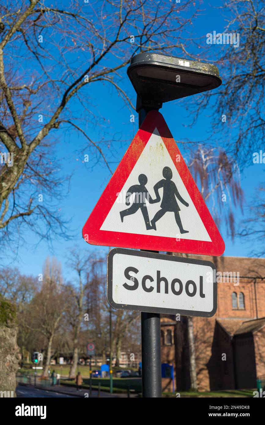 Triangle rouge d'avertissement de route près d'une école Banque D'Images