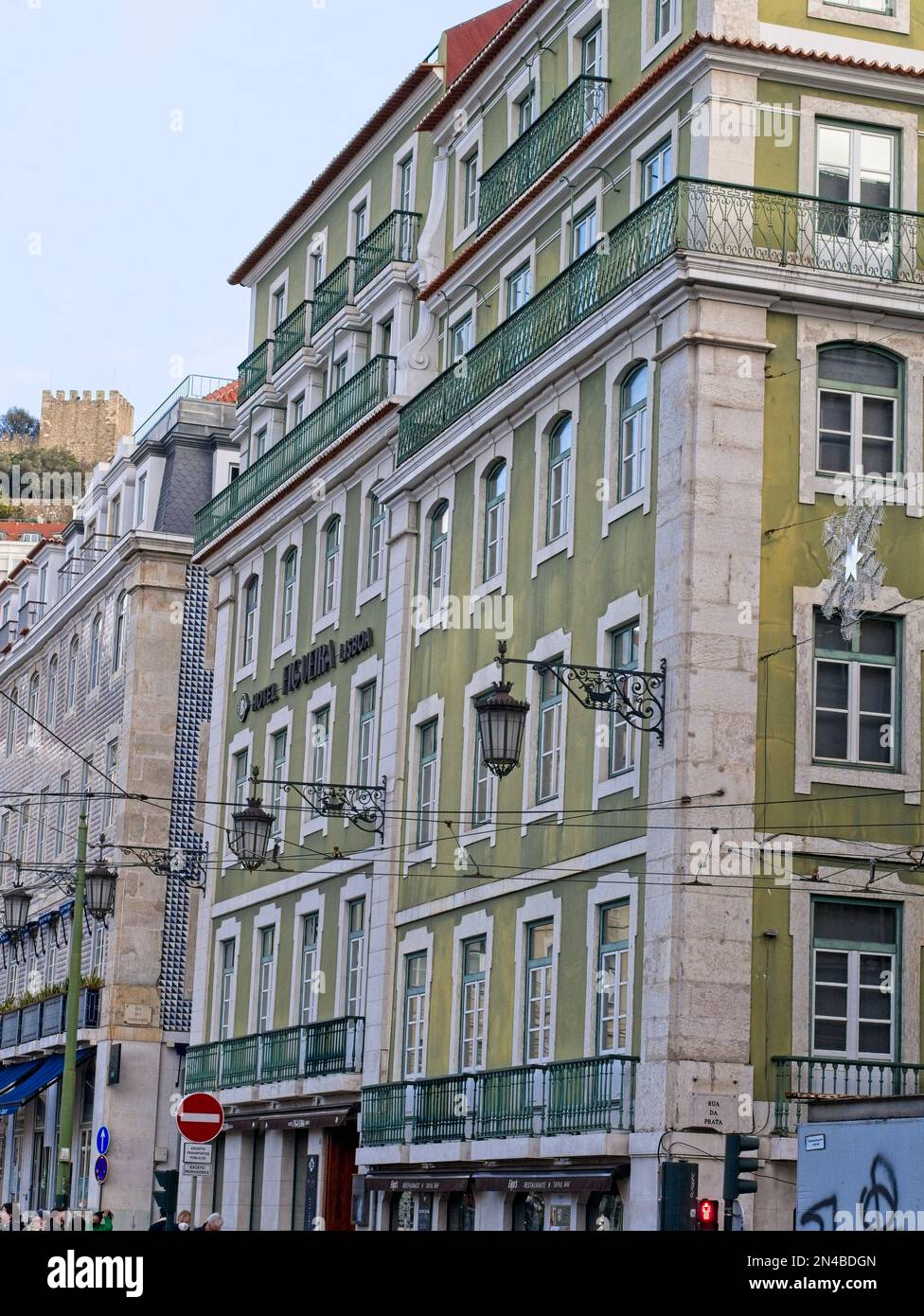 Vertical: Mousse légère, vert exemple de hauts en couleur, bâtiments historiques sur la Praca da Figueira, à Lisbonne, Portugal avec Saint George Castle en arrière-plan Banque D'Images