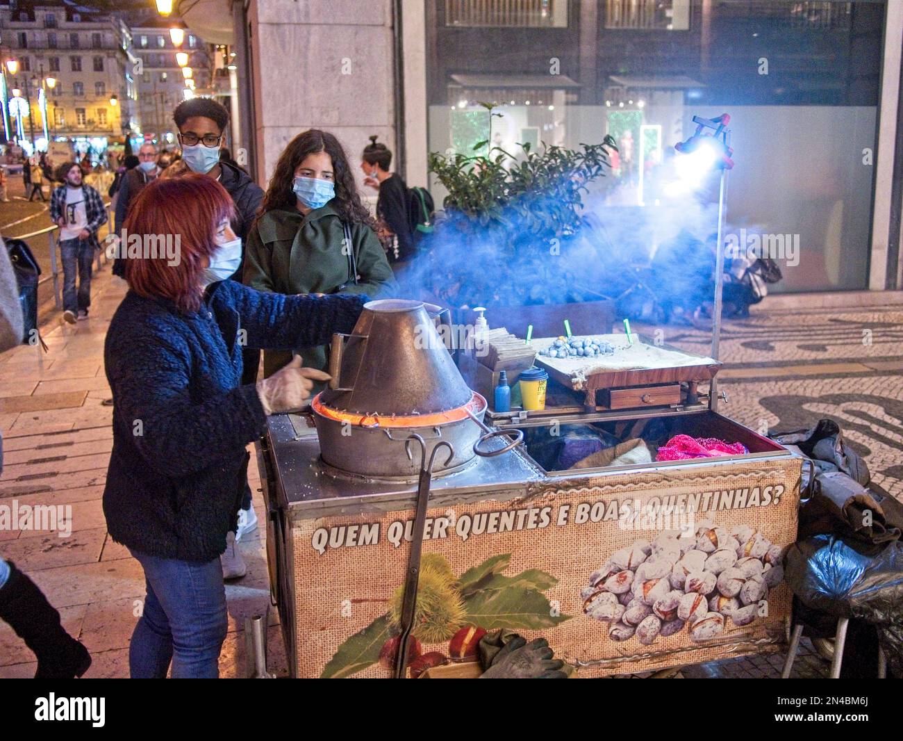 Un vendeur de rue fume des châtaignes dans la rue pendant la saison de Noël à Lisbonne, Portugal Banque D'Images