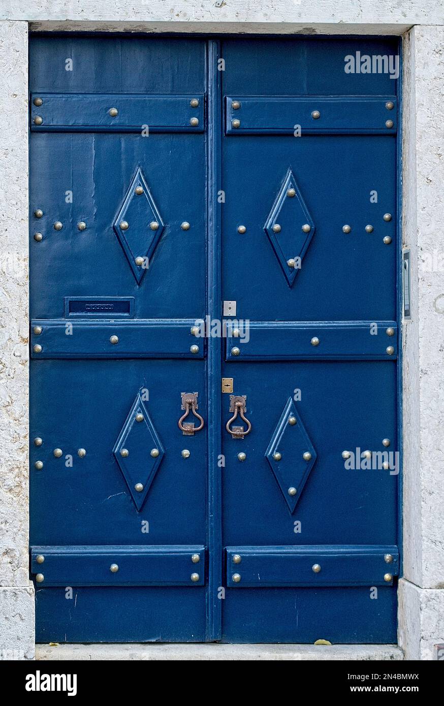 Vertical : porte antique, médiévale bleue avec poignées de porte en laiton rivets en métal brillant vieille ville Lisbonne, Portugal Banque D'Images