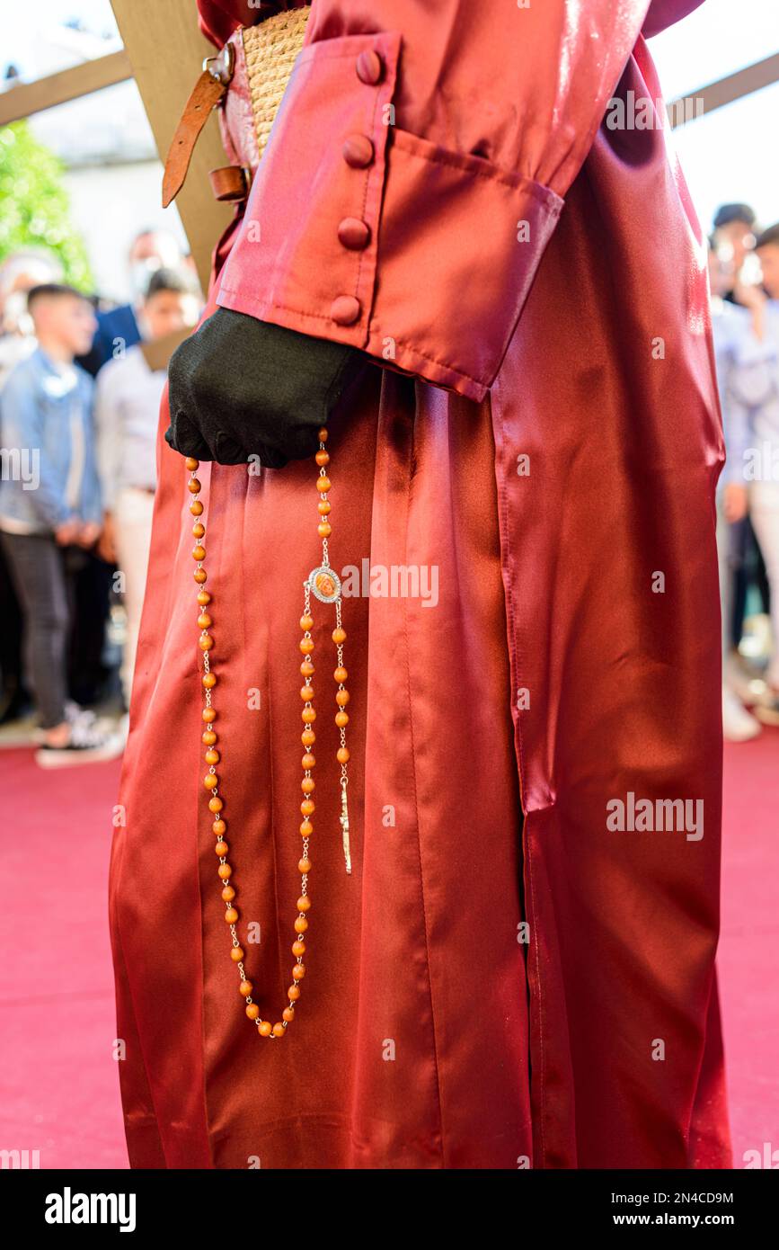 Arahal. Séville. Espagne. 14 avril 2022. Détail d'une main avec un rosaire d'un pénitent de la fraternité de la Misericordia, Arahal (Séville), pendant t Banque D'Images